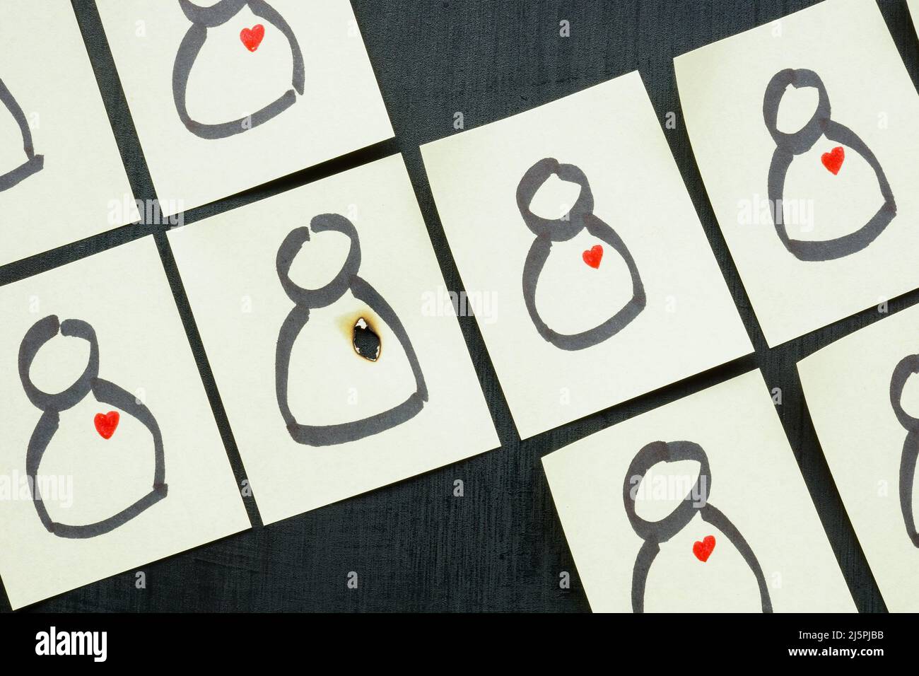 Difficoltà di relazione. Adesivi con figurine e uno con un cuore bruciato. Foto Stock