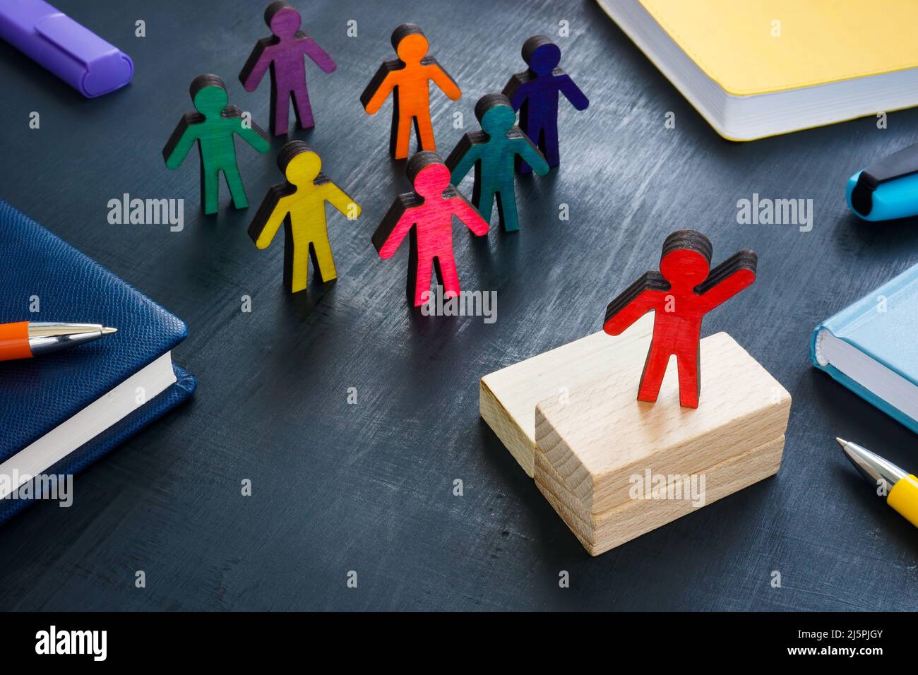 Figurine sulla scrivania dell'ufficio. Concetto di leadership culturale trasversale. Foto Stock