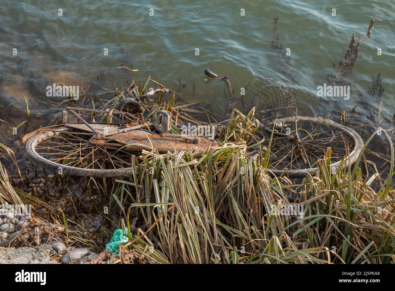Vista ad angolo alto di una bicicletta abbandonata da un fiume. Concetto di questioni ambientali, riciclaggio. Spazio di copia Foto Stock