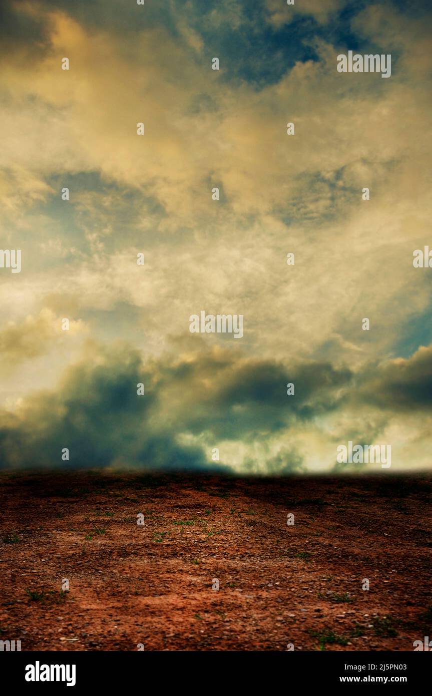 terra deserta e cielo drammatico sopra Foto Stock