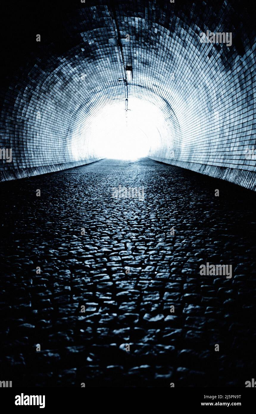 tunnel oscuro e misterioso con la luce alla fine Foto Stock