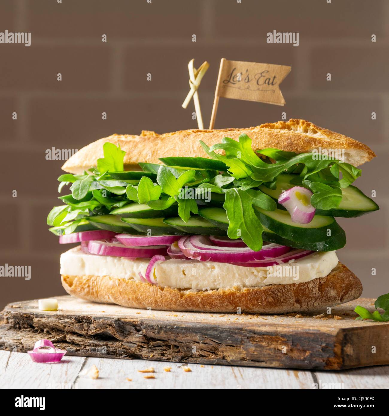 Sandwich fatto in casa con formaggio di capra e verdure fresche crude Foto Stock