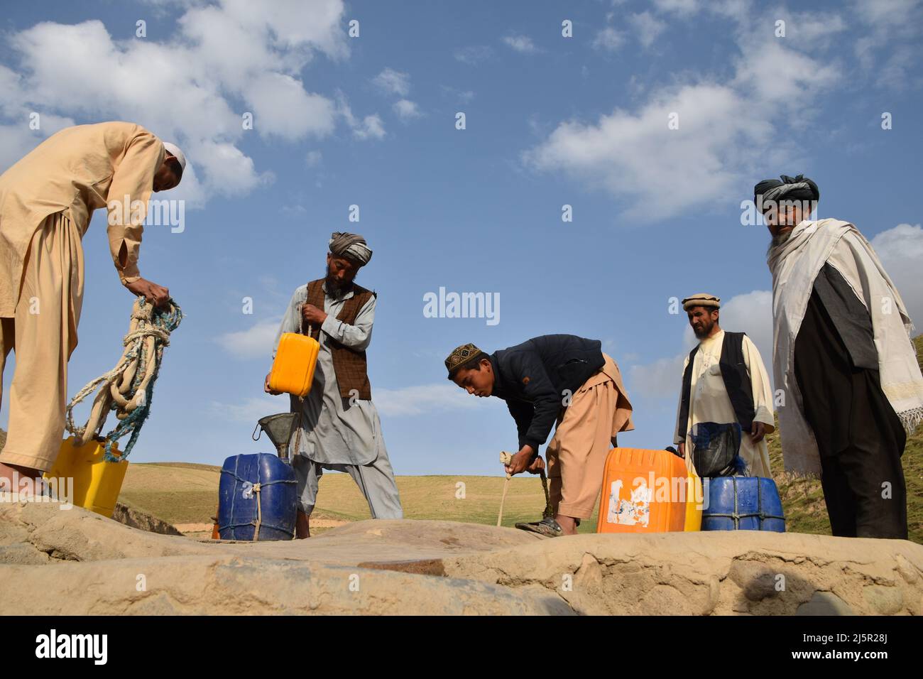 (220425) -- BAGHLAN, 25 aprile 2022 (Xinhua) -- gli abitanti di Villagers prelevano acqua potabile da un pozzo nella provincia di Baghlan, Afghanistan, 24 aprile 2022. Più di 3.000 famiglie nel villaggio di Hazarqaq nella provincia settentrionale di Baghlan si trovano ad affrontare una grave carenza di acqua, devono percorrere più di 6 chilometri per ottenere l'acqua per uso quotidiano. (Foto di Mehrab Ibrahimi/Xinhua) Foto Stock