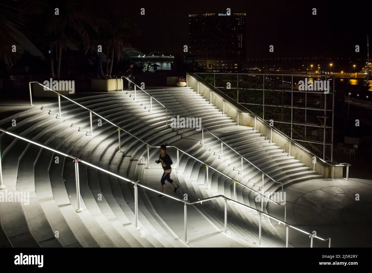 Giovane donna che corre alla scala del Centro Congressi di notte, San Diego Marina Foto Stock