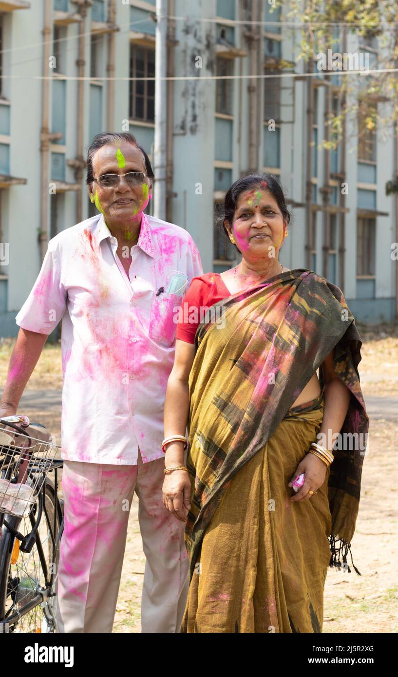 Una coppia indiana senior con volti colorati che giocano holi - il festival dei colori Foto Stock