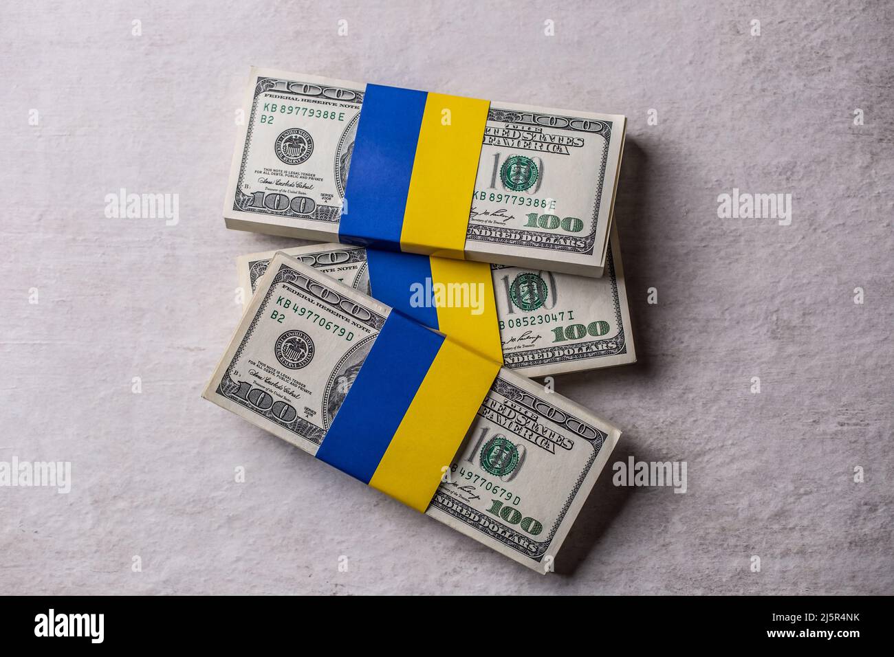 Pacchetti di bollette in dollari legate alla bandiera Ucraina. Il concetto di sostegno del governo americano, per i dilaniati dalla guerra Foto Stock