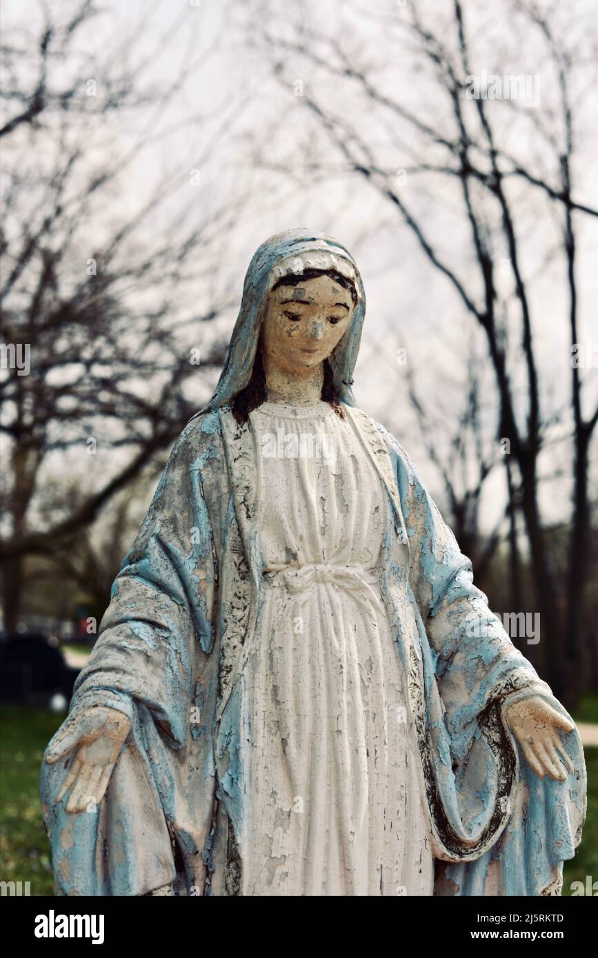 Statua in pietra femminile in un cimitero in inverno Foto Stock