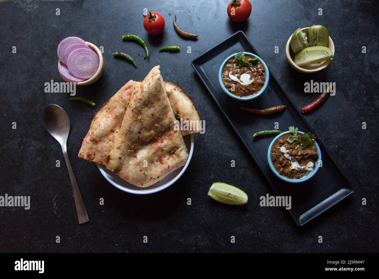 Zuppa dal makhni o lenticchie nere servita in una ciotola insieme ai condimenti. Messa a fuoco selettiva. Foto Stock