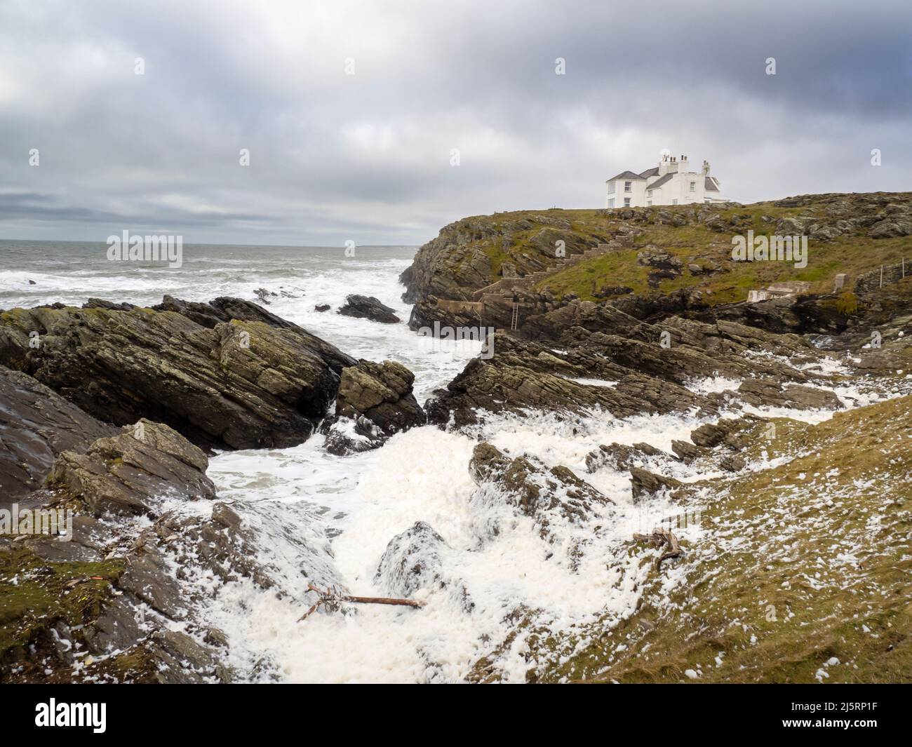 Schiuma montata dai venti della forza della tempesta su Holy Island, Anglesey, Galles, Regno Unito. Foto Stock