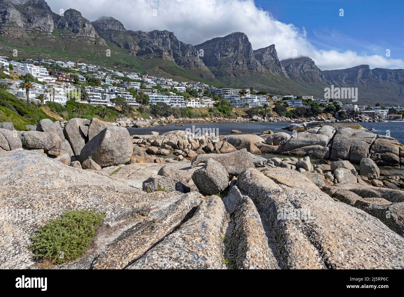Spiaggia rocciosa a Camps Bay / Kampsbaai e i dodici Apostoli, parte del complesso Table Mountain vicino a Città del Capo / Kaapstad, Capo Occidentale, Sudafrica Foto Stock