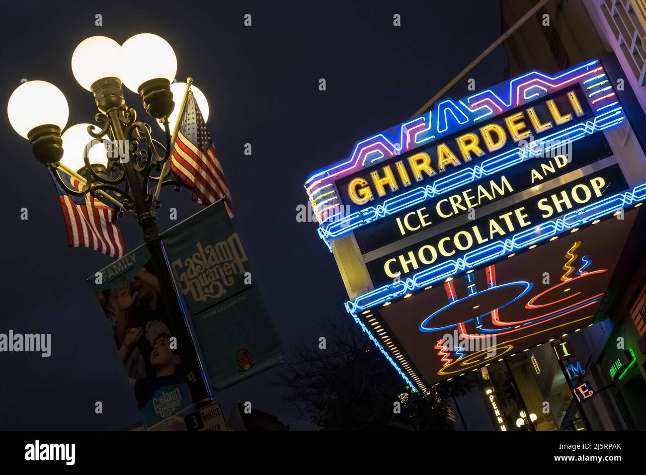 Foto notturna del cartello al neon illuminato Ghirardelli con un lampione su 5th Ave, quartiere Gaslamp, San Diego Foto Stock