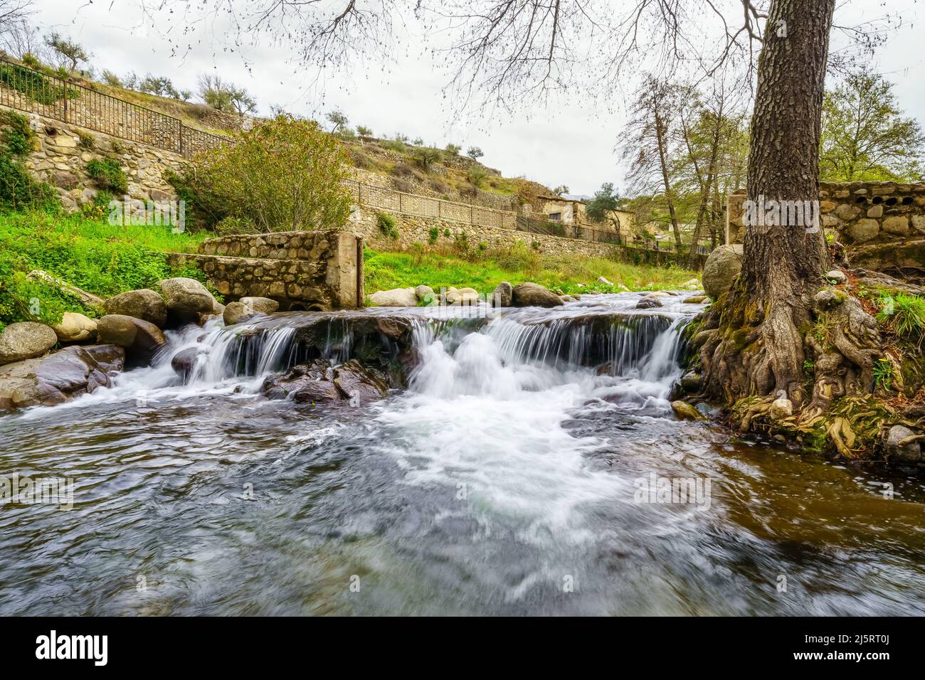 Torrente d'acqua che scende dalla montagna nel grazioso villaggio di Hervas, Caceres. Foto Stock