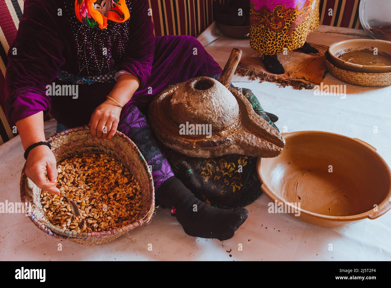 Donne che fanno olio di argan, Marocco. Tenere i semi con le mani. Persone reali che fanno cose reali. Africa Foto Stock