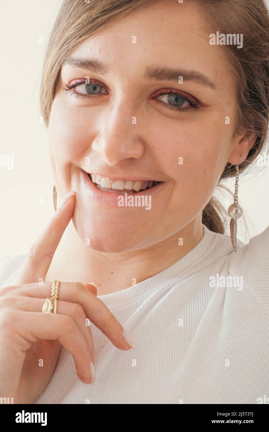 Primo piano ritratto viso di giovane donna con orecchino Foto Stock