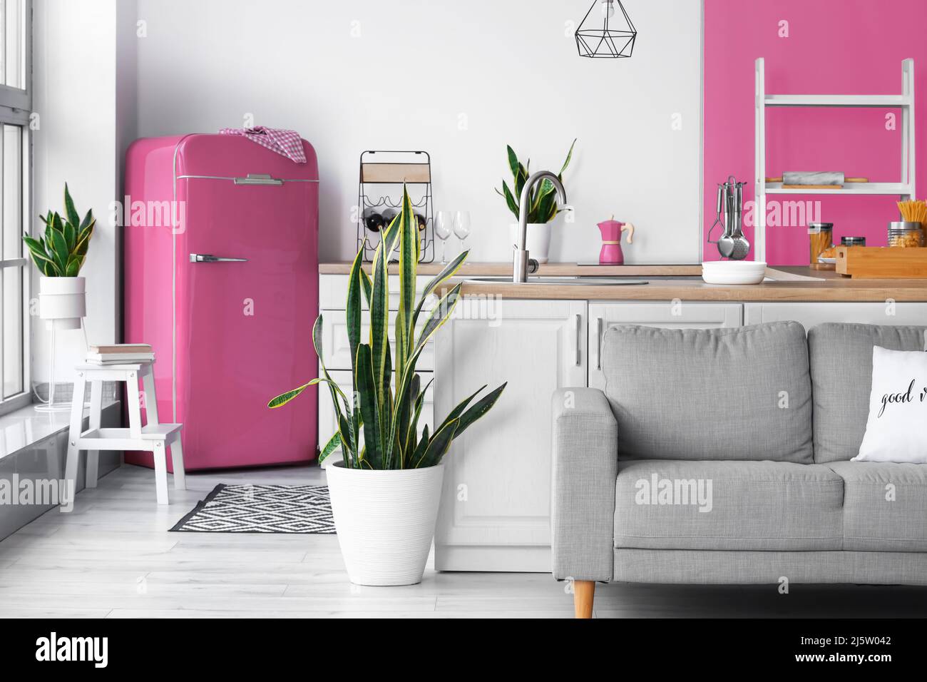 All'interno della moderna cucina con frigorifero rosa, ripiani e divano  Foto stock - Alamy