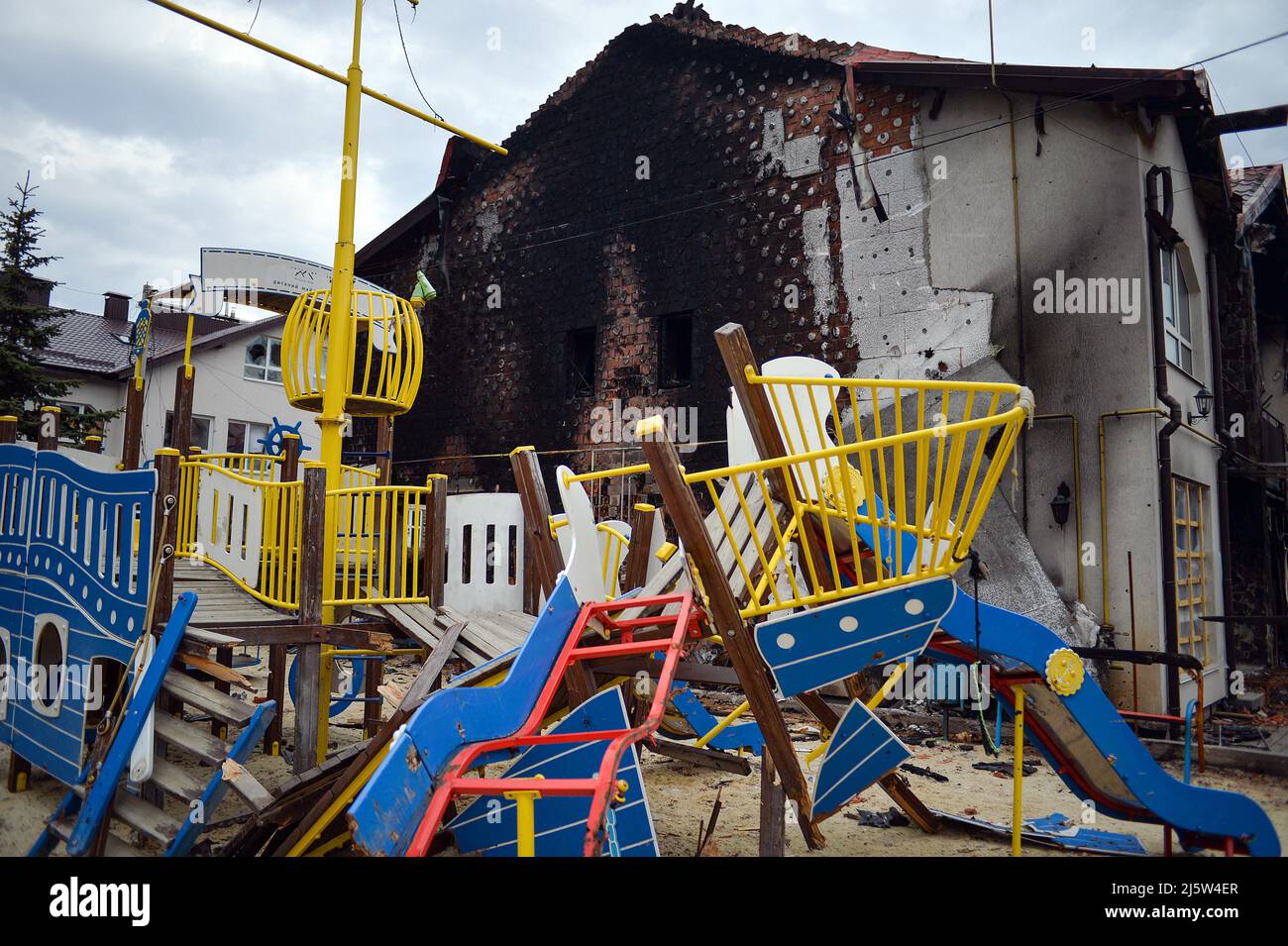 Kyiv Region, Ucraina, 25 aprile 2022. Un parco giochi distrutto e un edificio coperto di fuliggine alle sue spalle mostrano le conseguenze dell'invasione russa, Hostomel, Regione di Kiev, Ucraina settentrionale, aprile 25, 2022. Foto di Yevhen Kotenko/Ukrinform/ABACAPRESS.COM Foto Stock