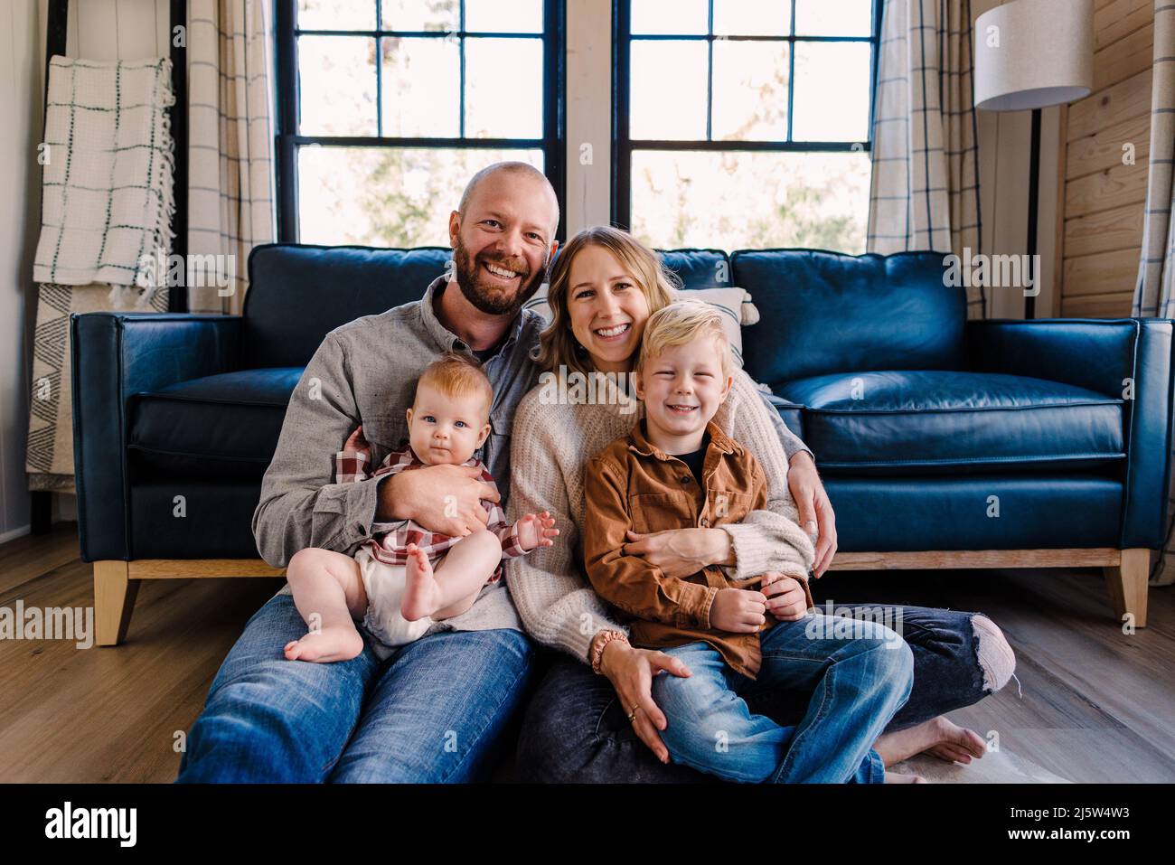 Una famiglia di quattro sorrisi alla telecamera mentre si siede in cabina durante la giornata di sole Foto Stock