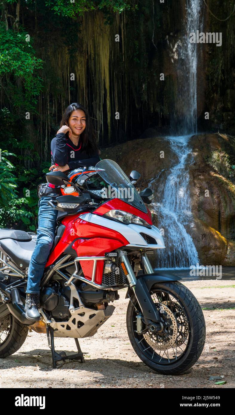 Donna tailandese che riposa sulla sua moto avventura nel nord della Thailandia Foto Stock