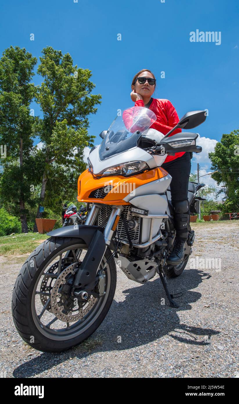 Donna tailandese che riposa sulla sua moto avventura nel nord della Thailandia Foto Stock