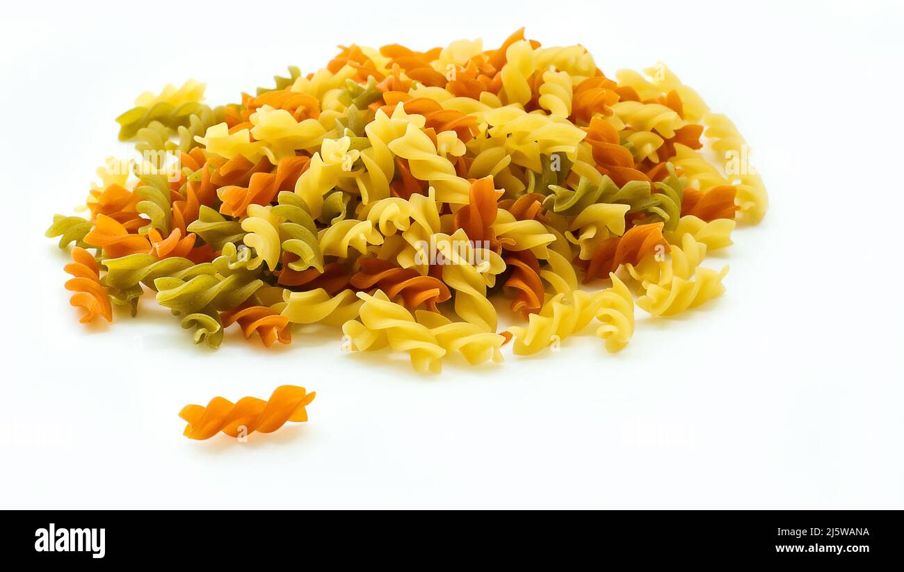 Primo piano pasta cruda multicolore isolata su sfondo bianco. Ingrediente alimentare Foto Stock