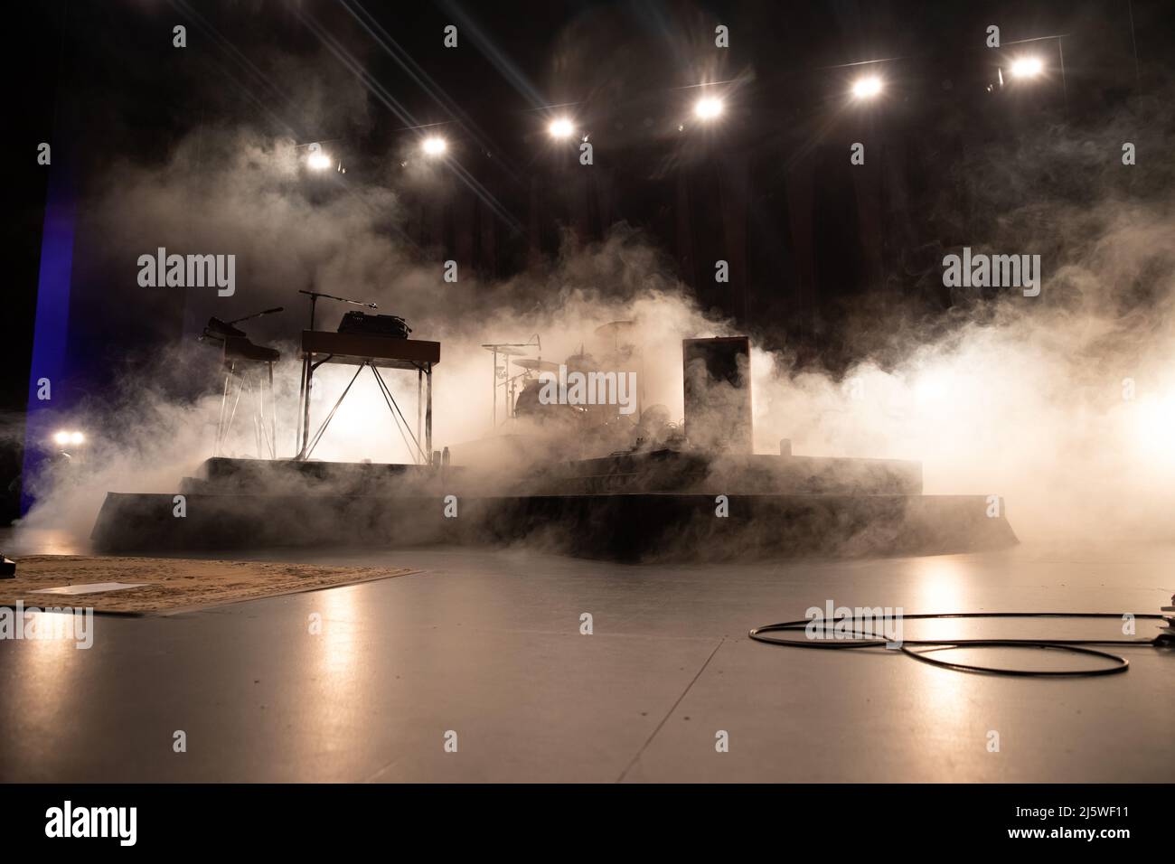Palcoscenico allestito per un concerto rock con illuminazione a fumo e palco Foto Stock