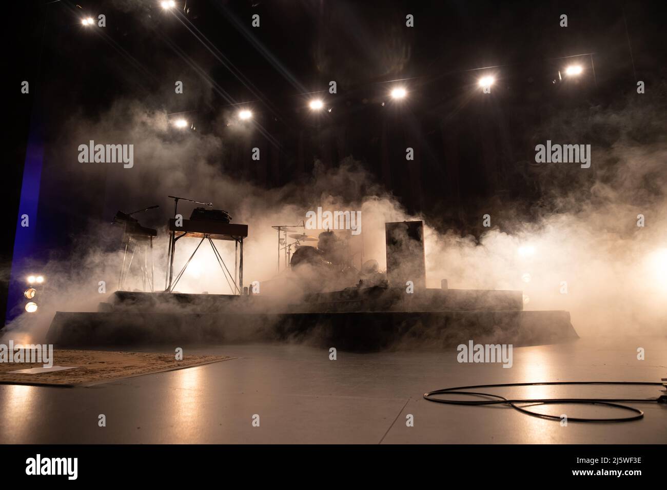 Palcoscenico allestito per un concerto rock con illuminazione a fumo e palco Foto Stock