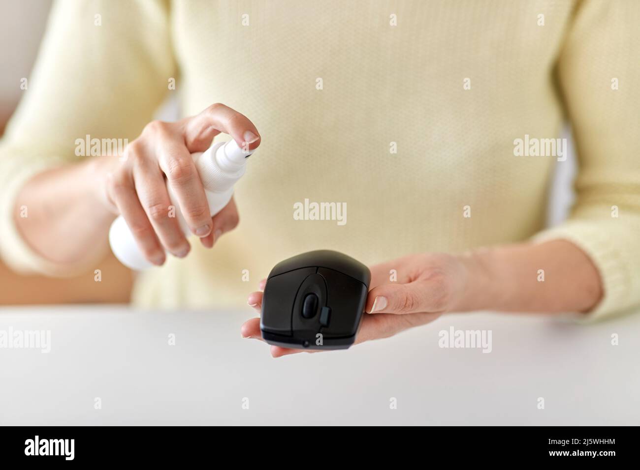 primo piano di donna che pulisce il mouse del computer Foto Stock