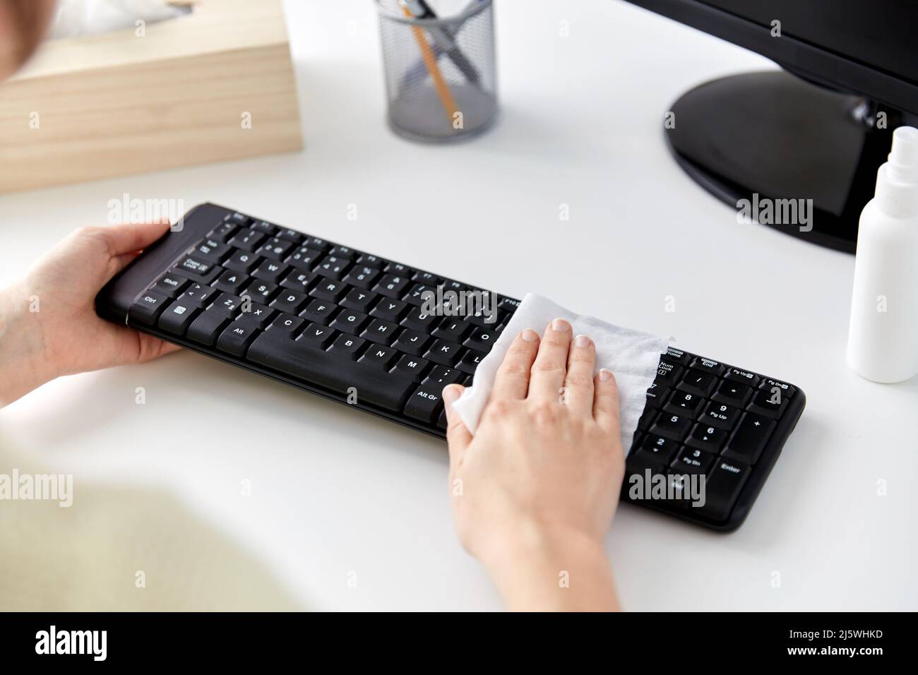 primo piano della donna che pulisce la tastiera con dei tessuti Foto Stock