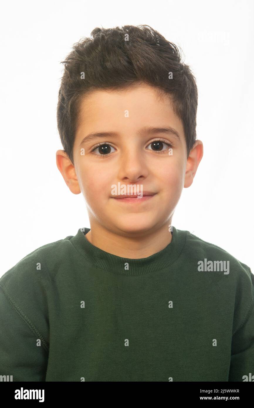 Bel ragazzo di 6 anni che guarda la macchina fotografica sorridendo su sfondo bianco Foto Stock