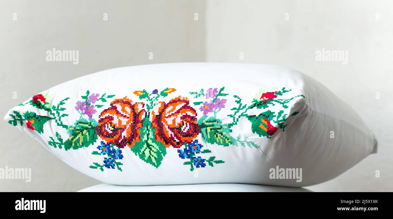 Fiori ricamati con fili su un cuscino bianco. Stile nazionale ucraino Foto Stock