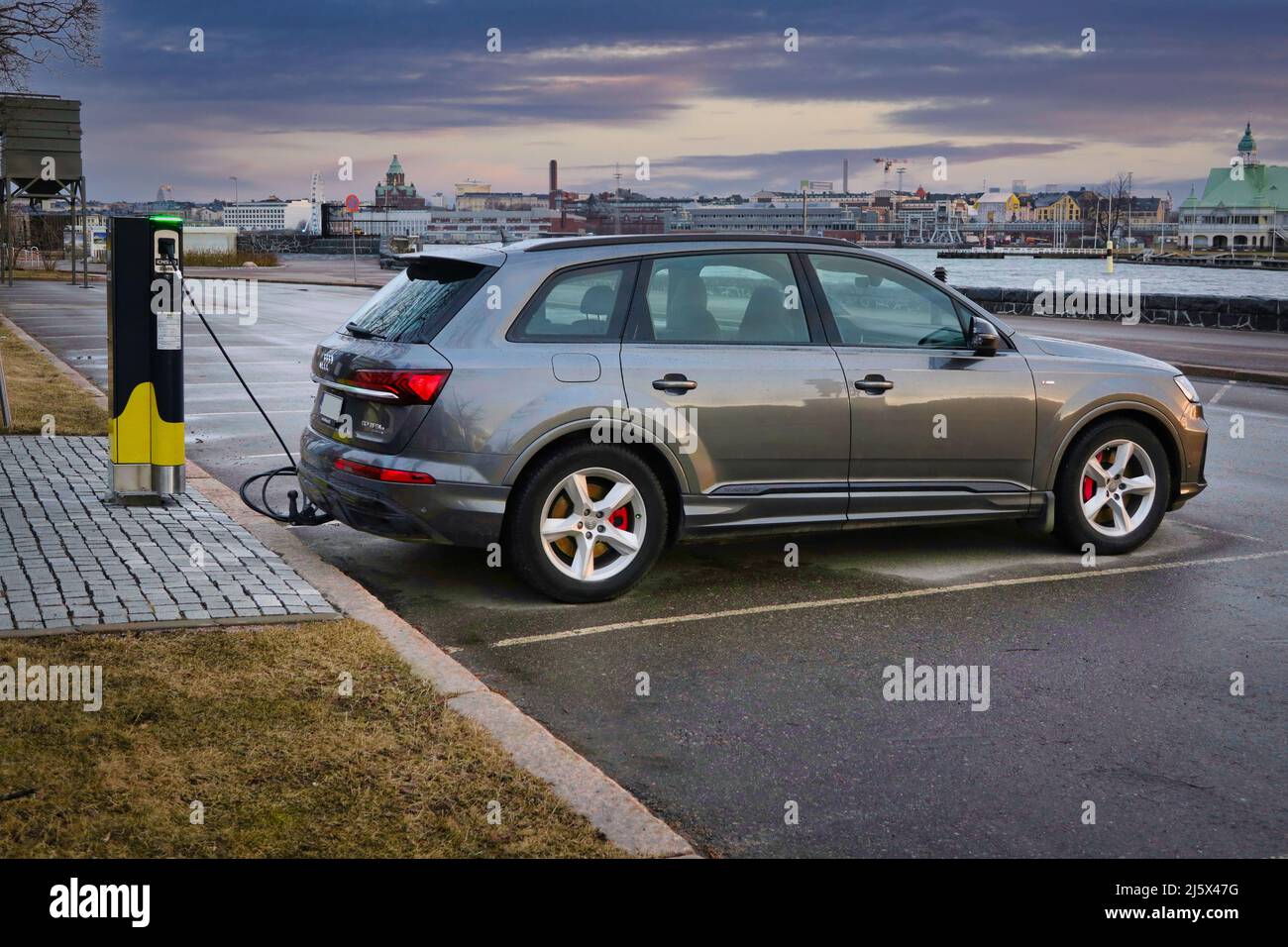 Audi Q7 60 TFSI e veicolo elettrico ibrido plug-in, PHEV, ricarica della batteria presso il punto di ricarica di Seaside Helen. Helsinki, Finlandia. Aprile 10, 2021. Foto Stock