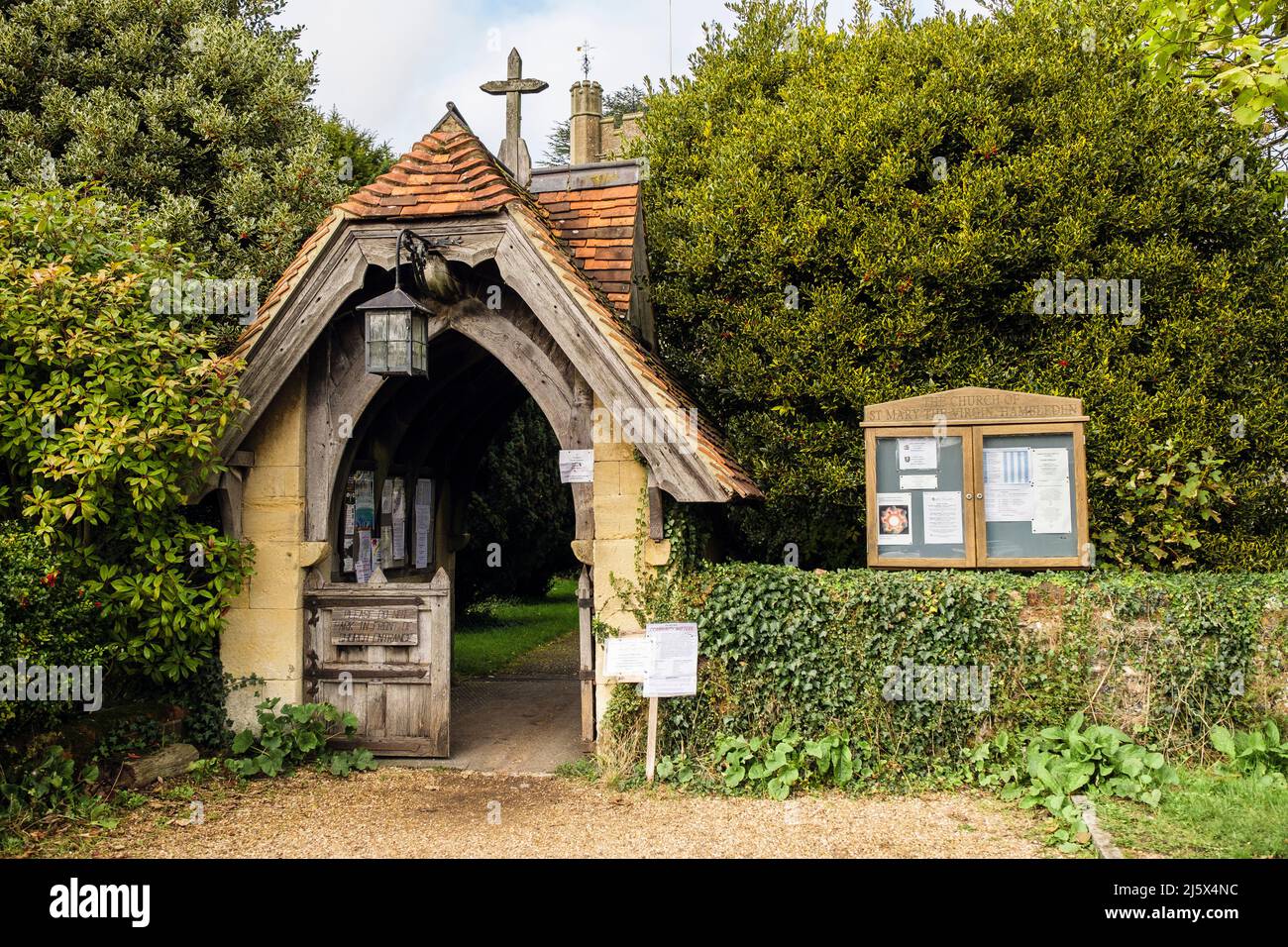 St Mary la Chiesa della Vergine Lychgate e bordo di avviso nel villaggio di Chilterns di Hambleden, Buckinghamshire, Inghilterra, Regno Unito, Gran Bretagna Foto Stock