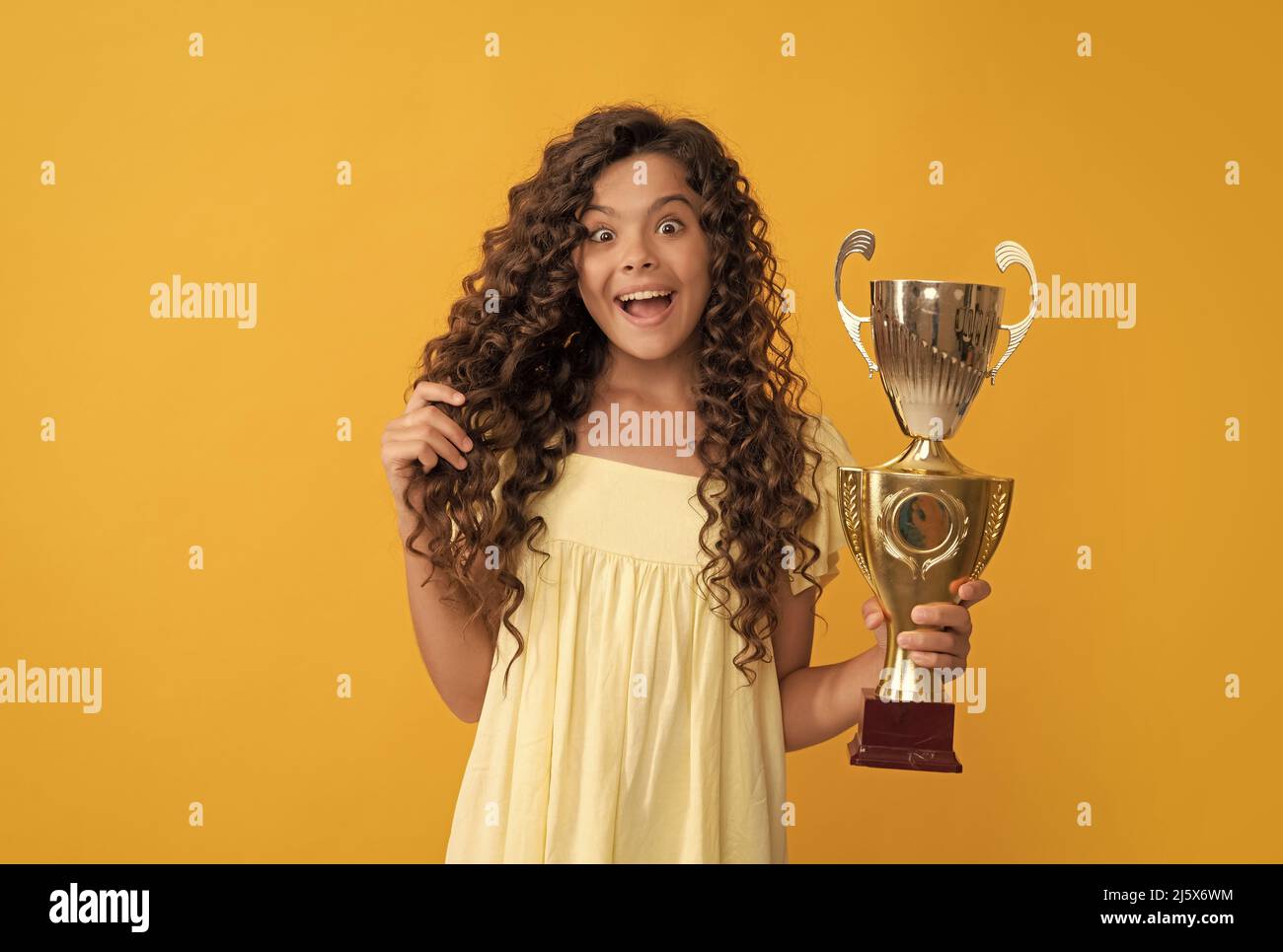sorprendo il bambino che tiene la coppa del campione d'oro come vincitore, premio Foto Stock