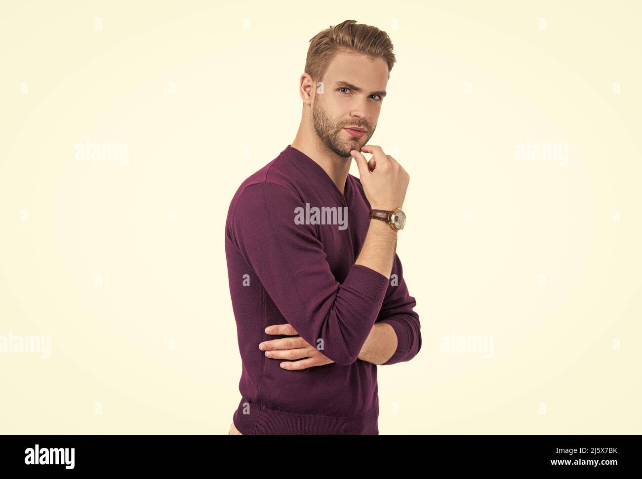 Per barba o non per barba. L'uomo bello tocca il mento non rasato. Cura del corpo maschile. Taglio dei capelli Foto Stock