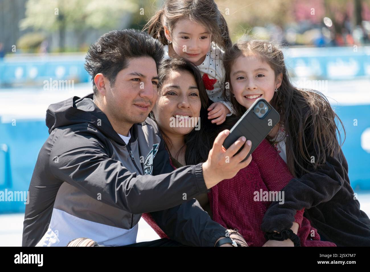Una famiglia latinoamericana stringe insieme per un selfie. In un parco a Queens, New York City. Foto Stock