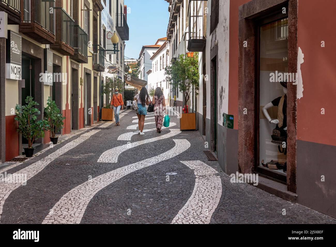 FUNCHAL, PORTOGALLO - 20 AGOSTO 2021: Questa è una delle strade pedonali con un mosaico di pavimentazione che è unico in questa strada. Foto Stock