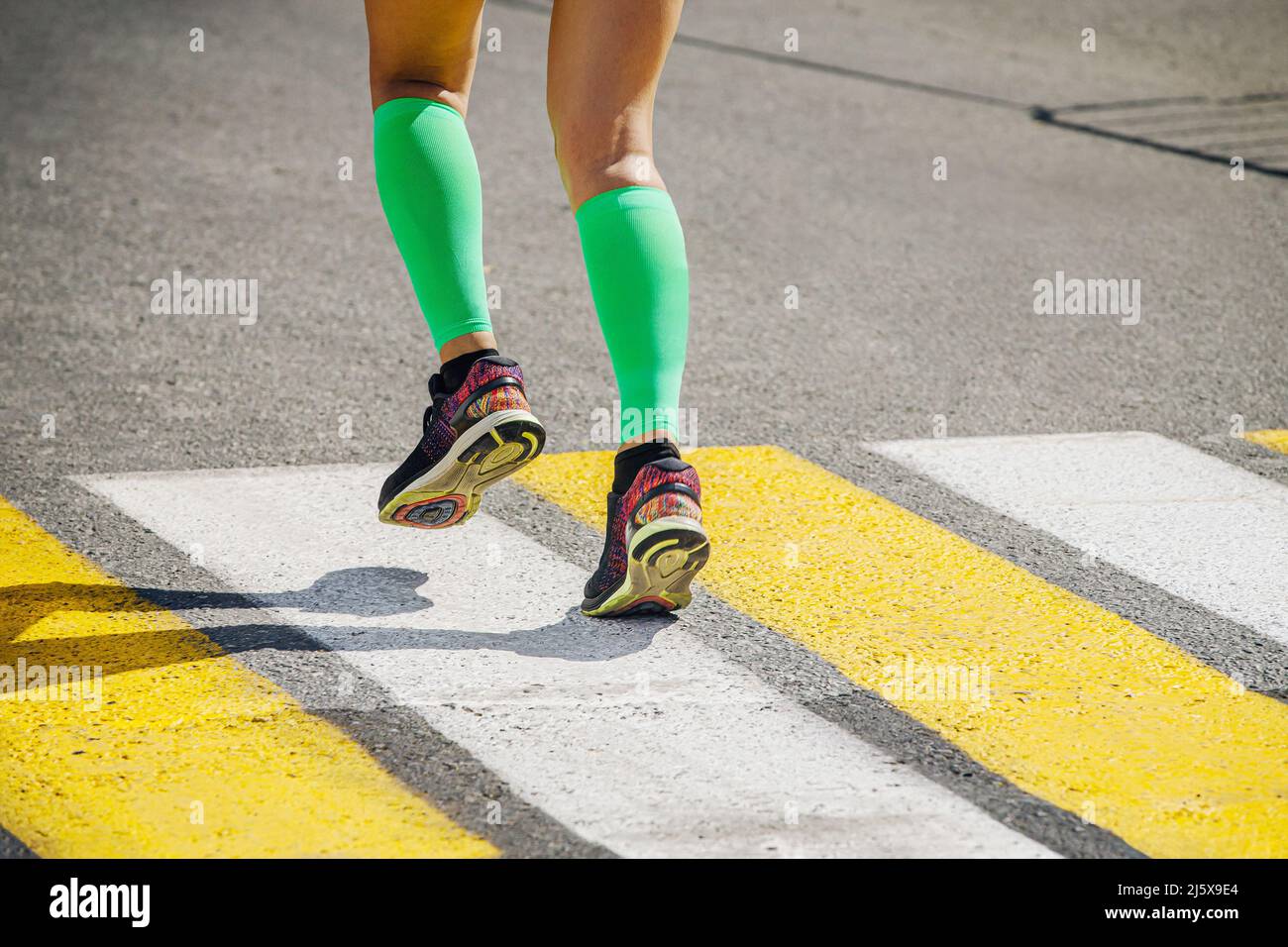 gambe girl runner in calze a compressione verde brillante Foto Stock