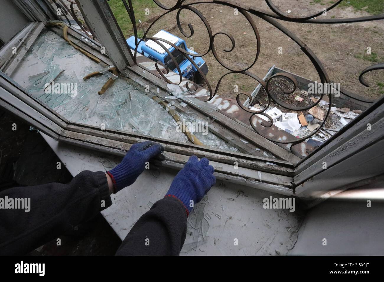 BORODIANKA, UCRAINA - 26 APRILE 2022 - Un uomo prende le barrette di vetro in un centro di risorse inclusive danneggiato durante l'invasione russa durante il restauro Foto Stock