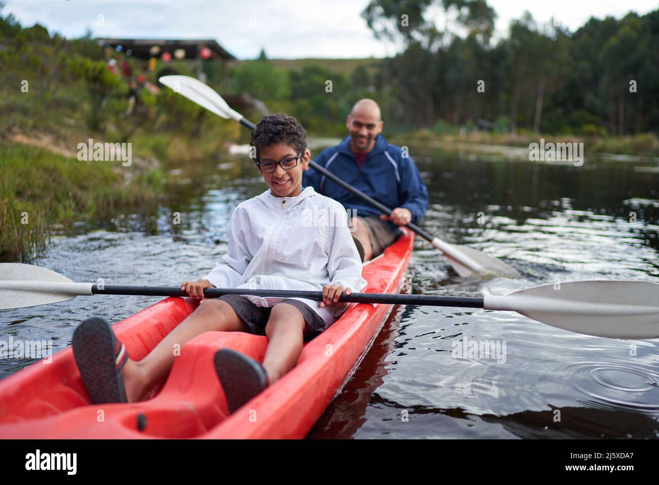 Ritratto felice padre e figlio kayak sul fiume Foto Stock