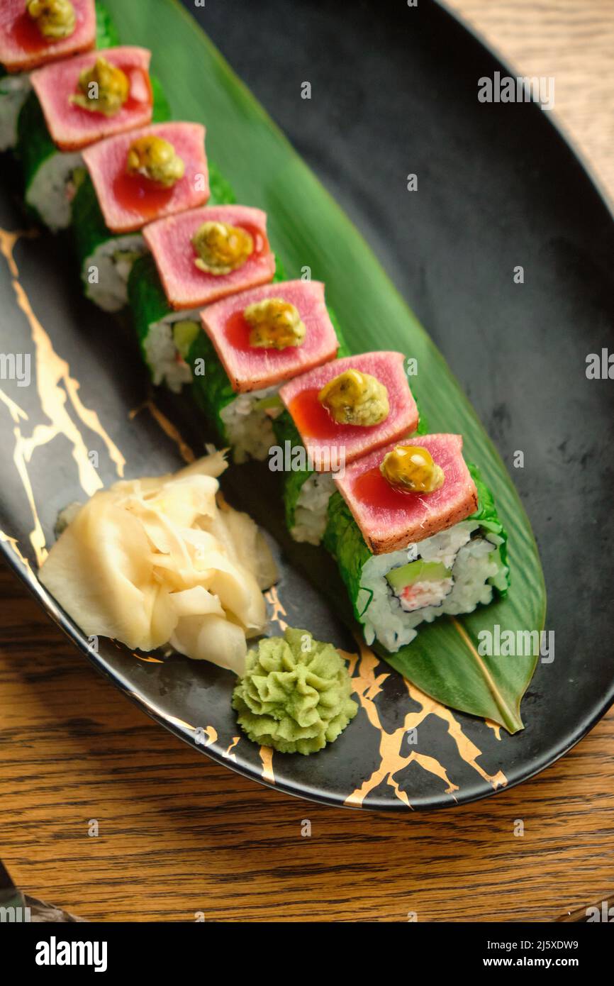 Un set di sushi freschi con salmone, avocado e semi di sesamo nero da vicino. Fuoco selettivo Foto Stock