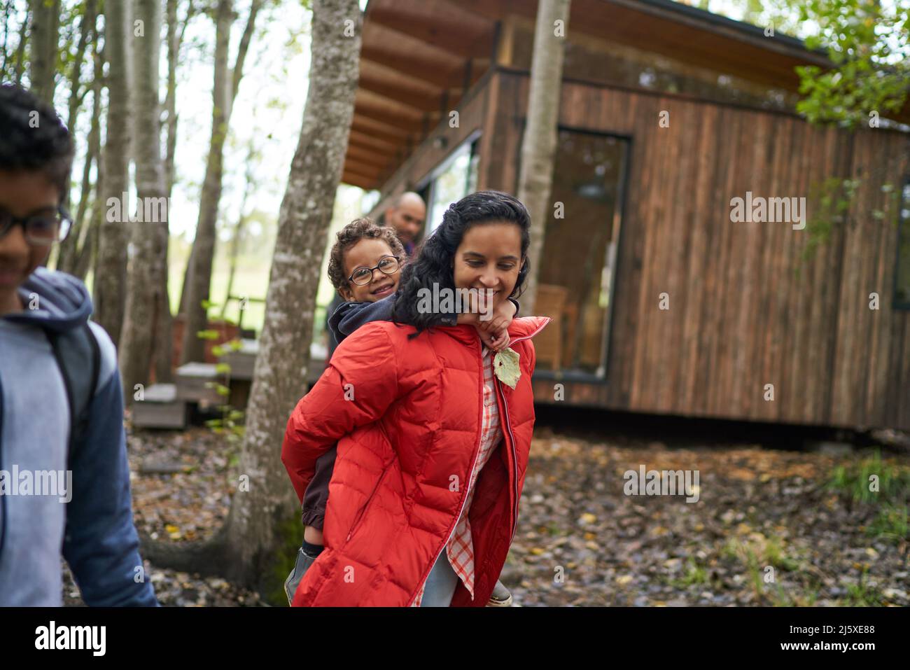 Ritratto madre piggybacking fuori cabina in legno Foto Stock