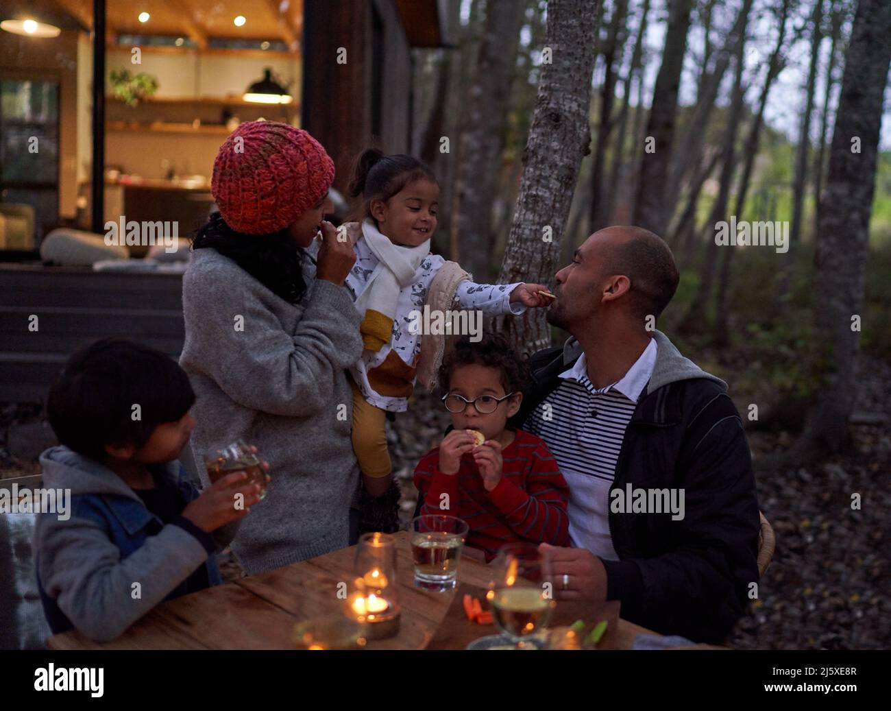 Famiglia che mangia al tavolo fuori cabina in legno Foto Stock