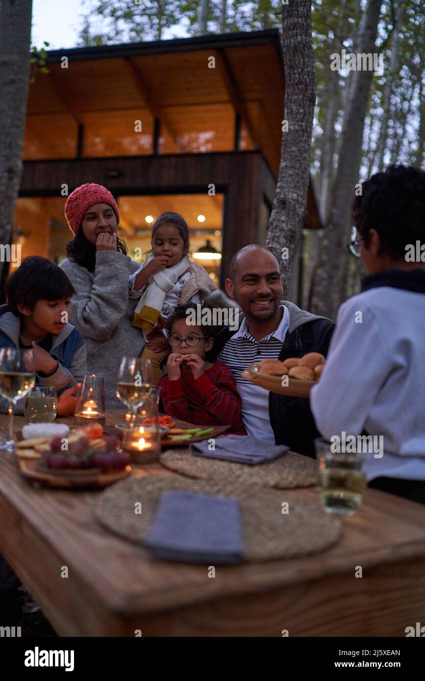 Famiglia che mangia al tavolo fuori cabina Foto Stock