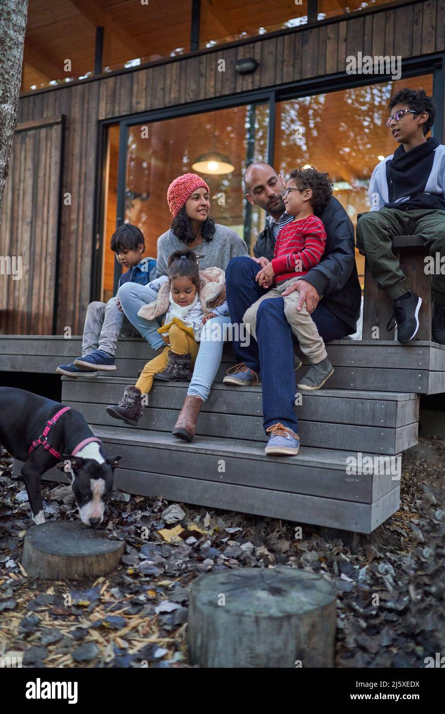 Famiglia che parla e rilassarsi sul patio della cabina Foto Stock