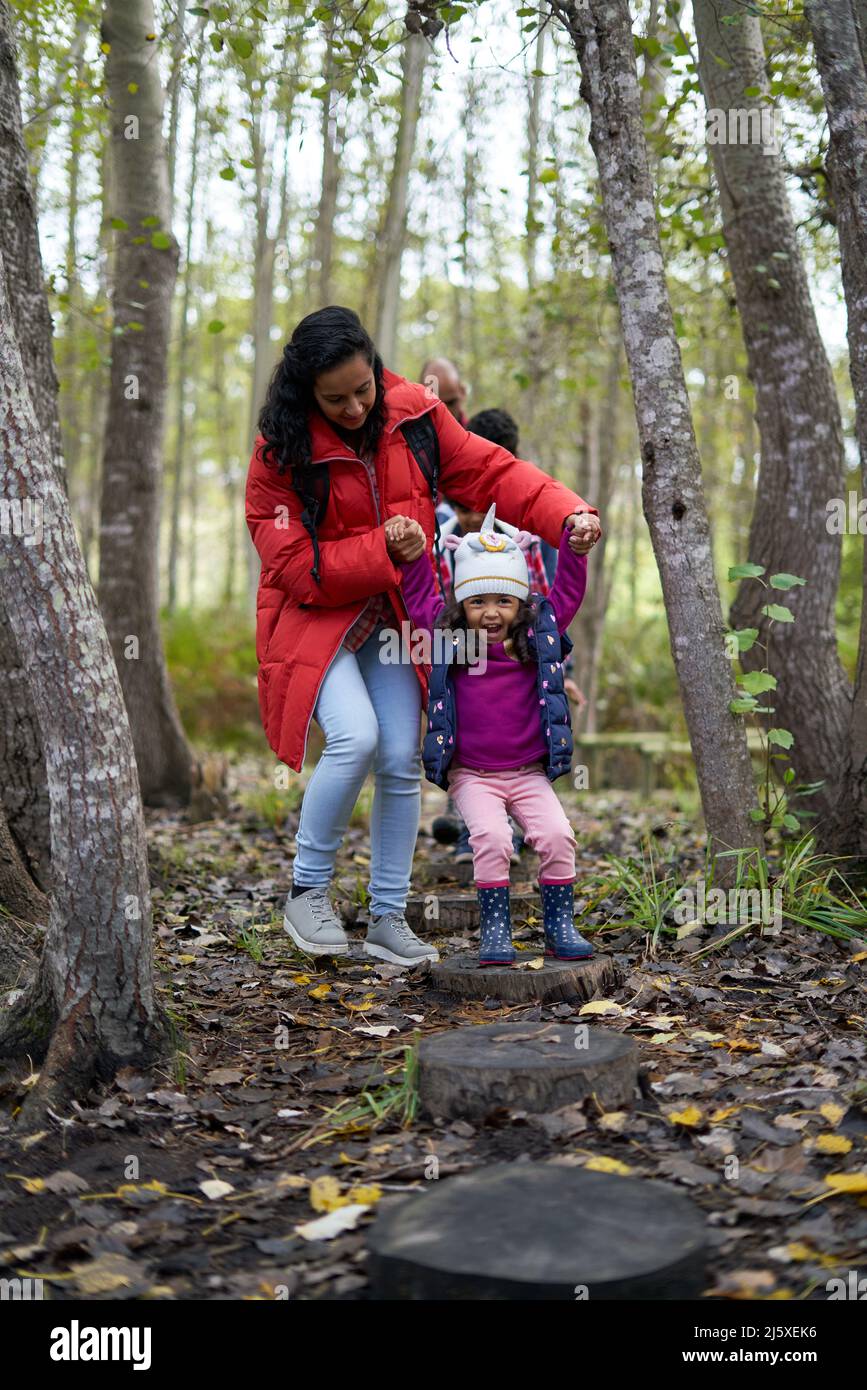 Madre e figlia giocosa su ceppo di legno in legno Foto Stock