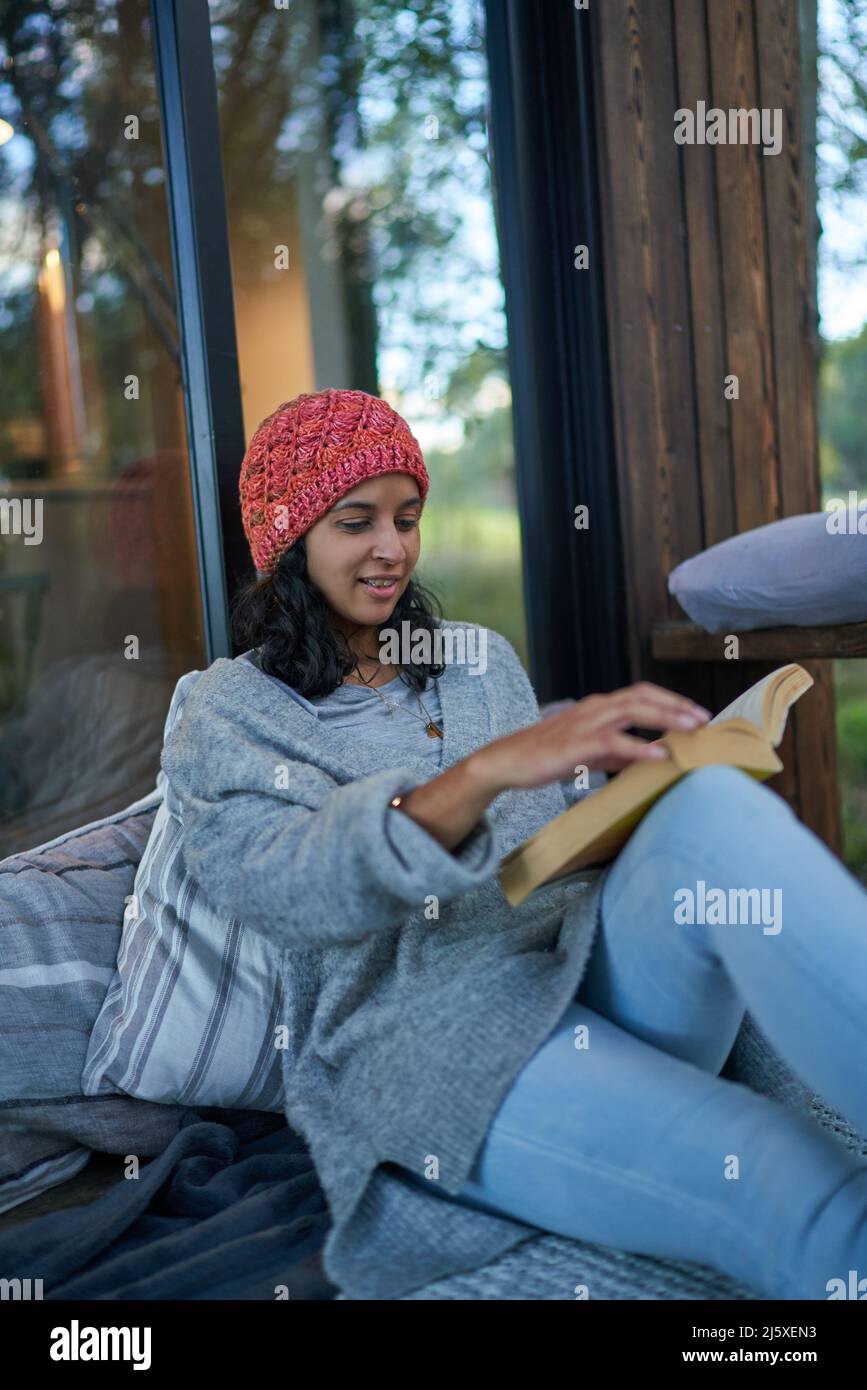 Donna rilassante e libro di lettura sul patio cabina Foto Stock
