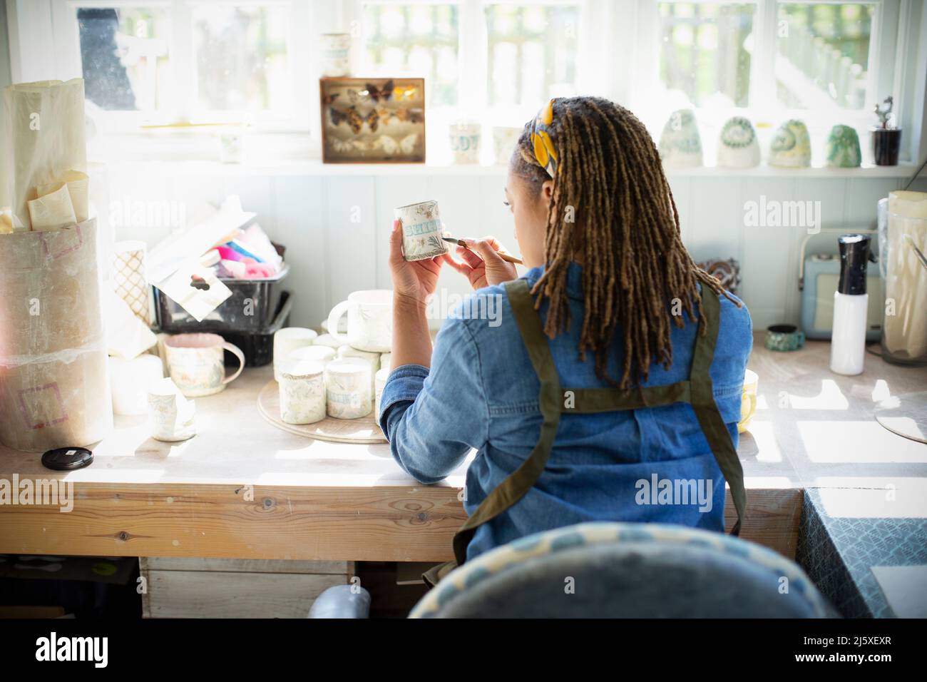 Giovane artista femminile che dipinge ceramiche in studio d'arte Foto Stock