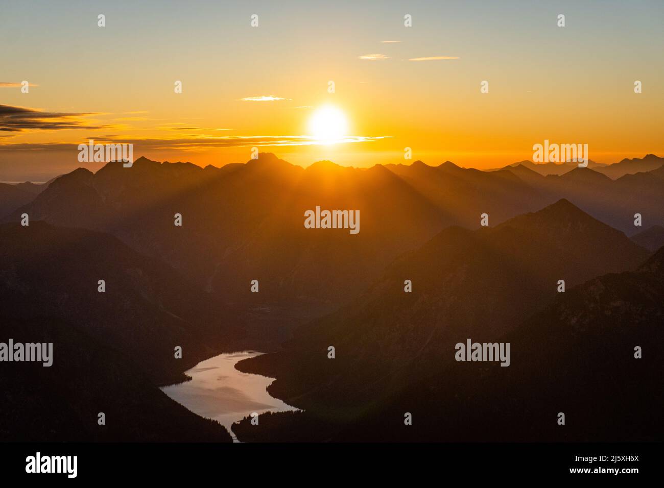 Abbiamo avuto la fortuna di godere l'alba in un giorno perfetto, con condizioni meteorologiche perfette, sopra questo bellissimo lago di Reutte. Foto Stock