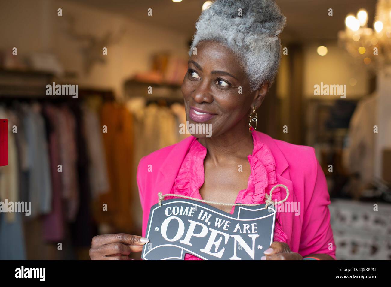 Ritratto fiducioso donna negozio proprietario con segno aperto in boutique Foto Stock