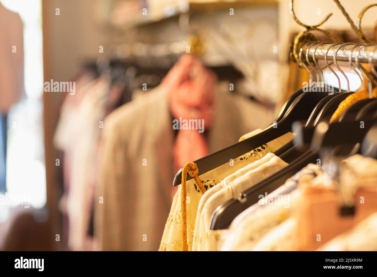 Vestiti su appendiabiti in boutique di abbigliamento Foto Stock